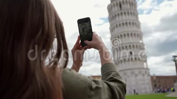 女人通过电话拍摄比萨斜塔的垂直照片后视图视频的预览图