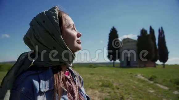 戴头巾的漂亮女孩在小礼拜堂上享受阳光的肖像视频的预览图
