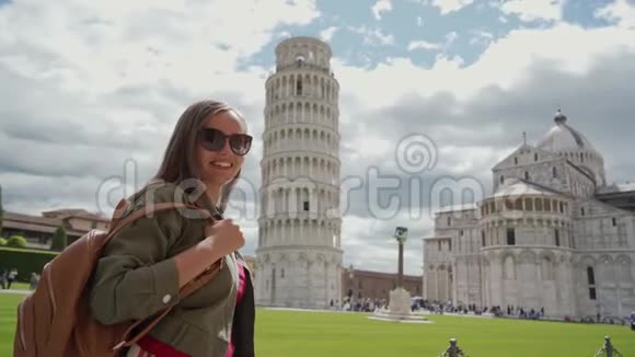 戴墨镜的女人站在著名的旅游景点比萨斜塔附近视频的预览图