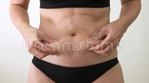 穿比基尼的白种人超重胖女人抱着她肥胖的胃并表现出她的肥胖减肥的概念视频的预览图