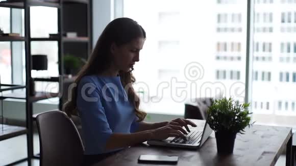 年轻的女商人坐在办公桌上打着公司的电子邮件视频的预览图