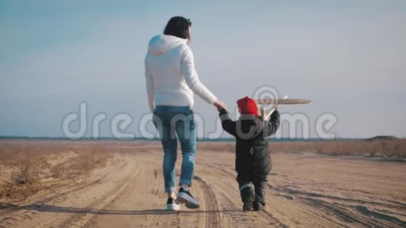 快乐的母亲和小儿子在日落时玩玩具飞机可爱的母子拥抱和玩玩具视频的预览图