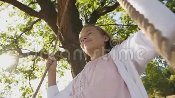 在夏天的时候女孩在绳子上荡秋千笑容满面视频的预览图