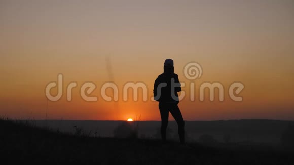 剪影女孩旅行者与背包徒步在山上日落徒步旅行自由和幸福视频的预览图