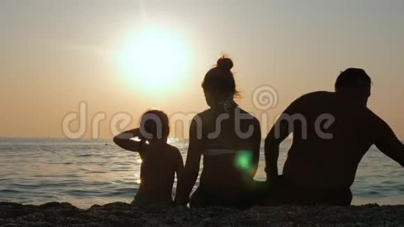 父母带着孩子在海边或海边享受日落视频的预览图