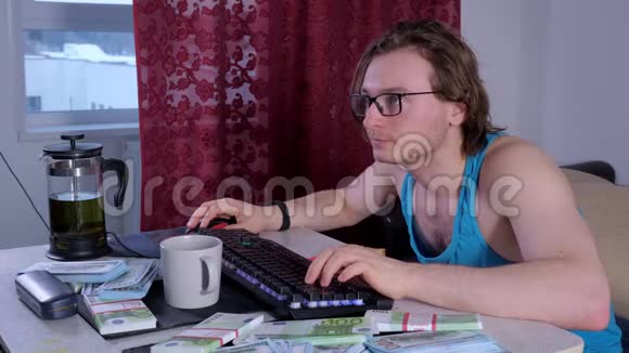 专注的男人在家里用台式电脑在网上赚钱视频的预览图