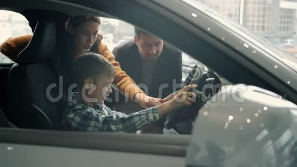可爱的小孩开着车和父母一起买汽车视频的预览图