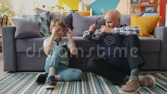 祖父和孙子戴着眼镜笑着在家玩的画像视频的预览图
