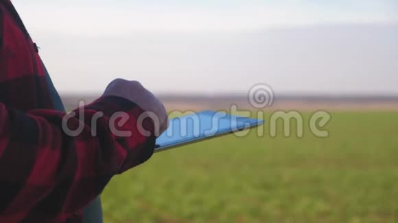 在日落时分在农业中使用现代技术站在绿色田野上的高级农民利用现代农业视频的预览图