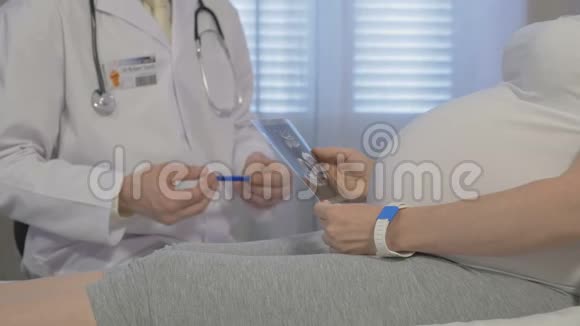 一位医生在他的办公室里检查一位孕妇视频的预览图
