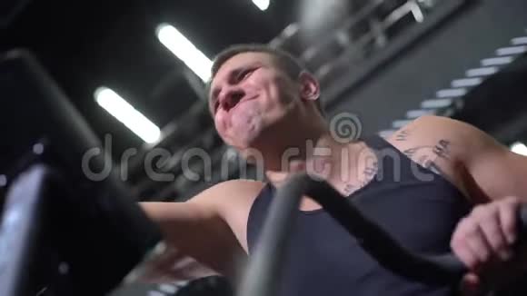肌肉男在训练模拟器上做运动的特写脸视频的预览图