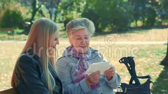 老妇人给她漂亮的孙女看一封信视频的预览图