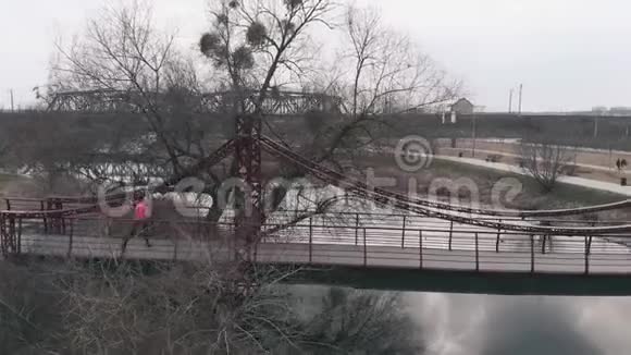 白人女运动员正在城市公园里过河女人在公园里做户外早操空中无人机视野视频的预览图