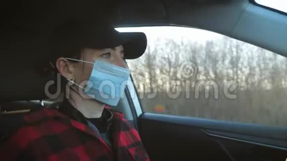 带着医疗面具的女孩为了防止病毒驾驶汽车冠状病毒的概念视频的预览图