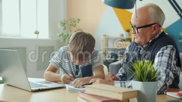 快乐的孩子和爷爷一起做家庭作业高举大拇指视频的预览图