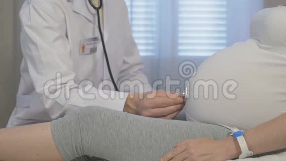 一位医生在他的办公室里检查一位孕妇视频的预览图