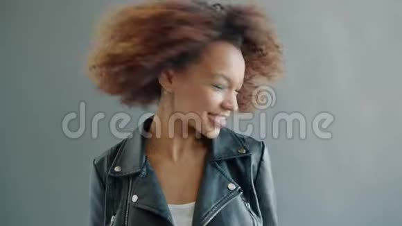 欢乐女孩模特在灰色背景上挥舞着头微笑的肖像视频的预览图