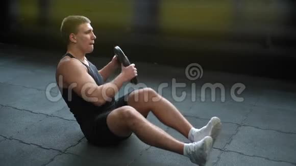 肌肉强壮的男子做俄罗斯扭转运动与体重从杠铃视频的预览图