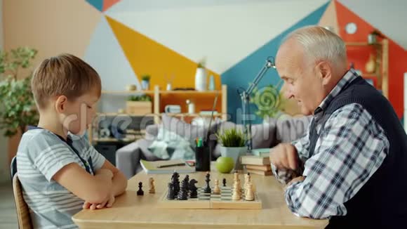 祖父和孙子下棋的肖像棋手在船上视频的预览图