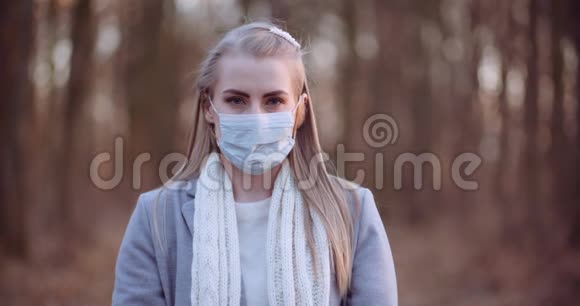 戴着防护面具的女人手里拿着冠状病毒铭文视频的预览图