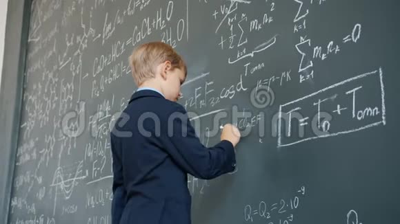 年轻的学生在学校里写字写黑板忙于科学视频的预览图