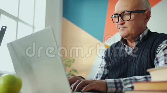 一位严肃的老人在室内使用笔记本电脑的画像视频的预览图