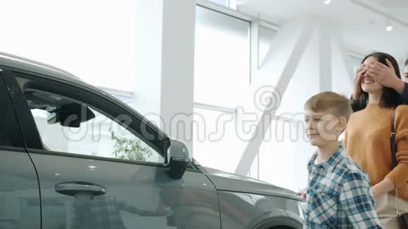 快乐的女士慢慢地从丈夫和儿子那里得到汽车作为礼物拥抱着笑视频的预览图