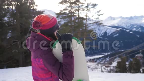 滑雪场山顶带滑雪板的女孩滑雪板冬季运动与寒假概念晴朗的冬天视频的预览图