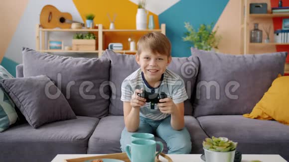 儿童在公寓玩电子游戏的缓慢动作赢得庆祝成功视频的预览图