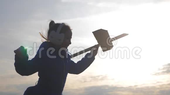 可爱的孩子在日落时在田里玩玩具木飞机小孩玩木飞机的剪影视频的预览图