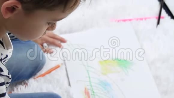 一个快乐的孩子画在纸上想象着家自然和家庭孩子们闲暇从上面看到的视频的预览图