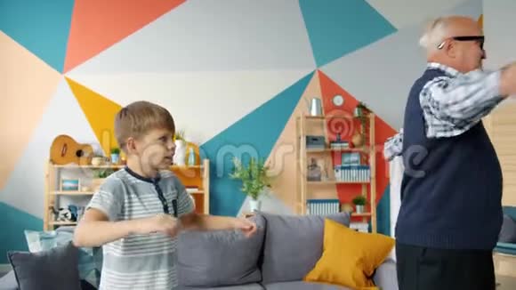 老人和小男孩在公寓里做体育锻炼视频的预览图