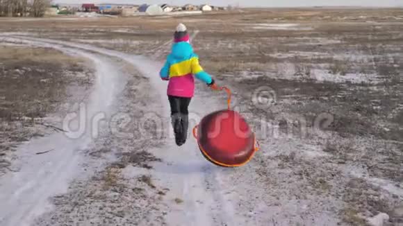年轻女孩骑在一座小山上的充气雪管上视频的预览图