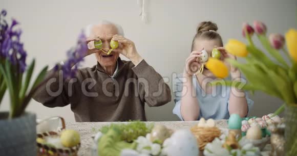 复活节快乐的祖父和孙女在复活节玩复活节彩蛋视频的预览图