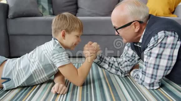 老人和小男孩在家进行摔跤享受活动视频的预览图