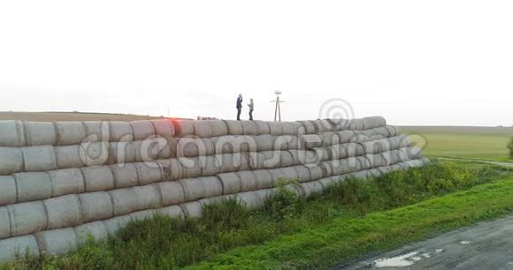 农业成功的农民站在稻草堆的顶端视频的预览图