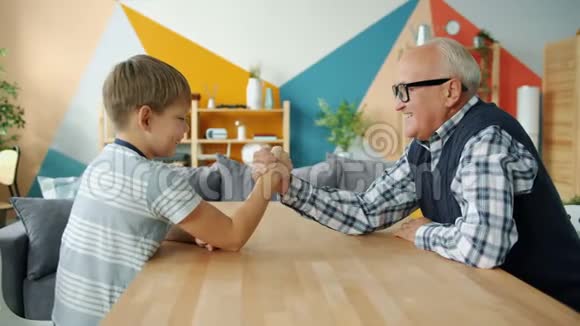 照顾的祖父教男孩摔跤在家做运动视频的预览图