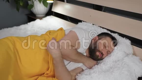 人躺在被黄格子包裹的床上他摇晃着冻僵了身体感冒流感病毒急性呼吸道疾病视频的预览图