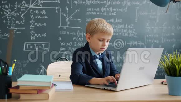 年轻的天才在学校独自使用笔记本电脑集中精力学习视频的预览图