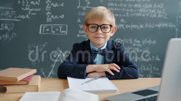 教室里戴着眼镜微笑着坐在桌前的小天才画像视频的预览图