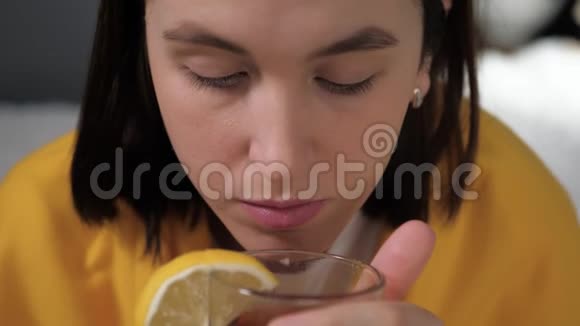 前景女孩正在喝红茶迷人的年轻女子病了坐在床上喝着柠檬茶视频的预览图