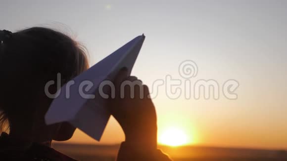 快乐的小女孩在日落时在户外玩纸飞机概念大童梦视频的预览图