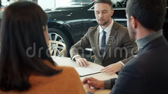 幸福夫妇买车签合同和销售经理谈五个字视频的预览图