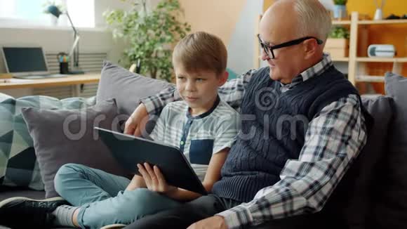 幸福的家庭祖父和孙子在家里用平板电脑聊天视频的预览图
