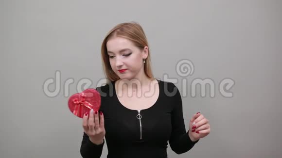 幸福的女人手里拿着一个红色心形礼盒手掌朝上视频的预览图
