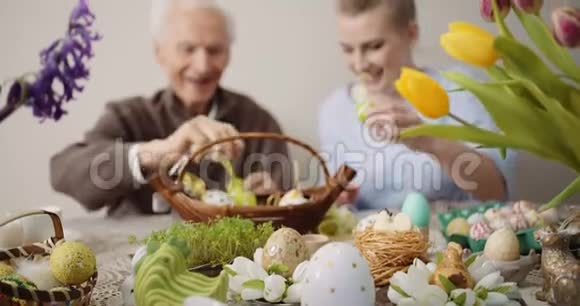 复活节快乐爷爷和孙女准备复活节装饰品视频的预览图