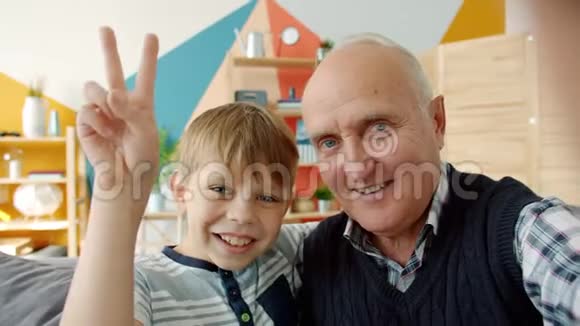 快乐的祖父和孙子在家自拍看镜头的POV视频的预览图