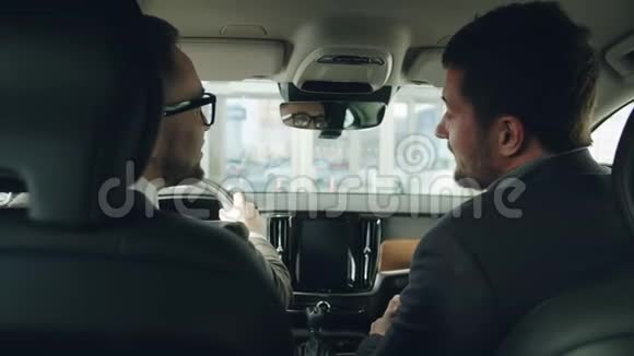 男性顾客选择汽车与坐在汽车里的经销商交谈视频的预览图