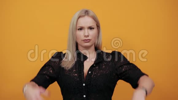 穿黑色衣服的女孩穿黄色背景的时髦女人把手放在头后面视频的预览图