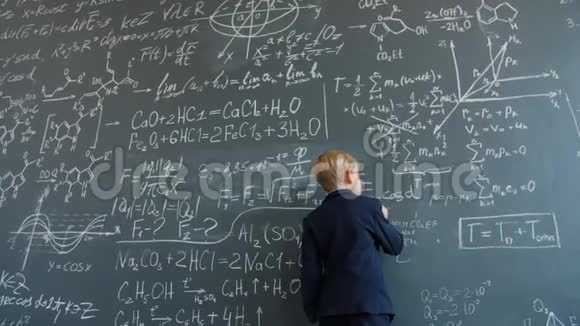 孩子们在黑板上写西装在宽敞的教室里忙于科学计算视频的预览图